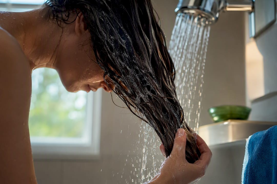 1790239199606_Hair-strands-rinsed-beneath-hard-water