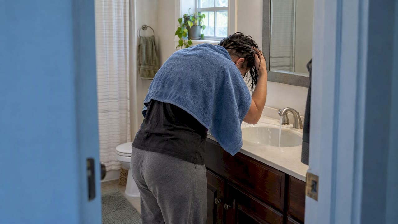 1791636043572_Person-rinsing-hair-at-a-home-sink